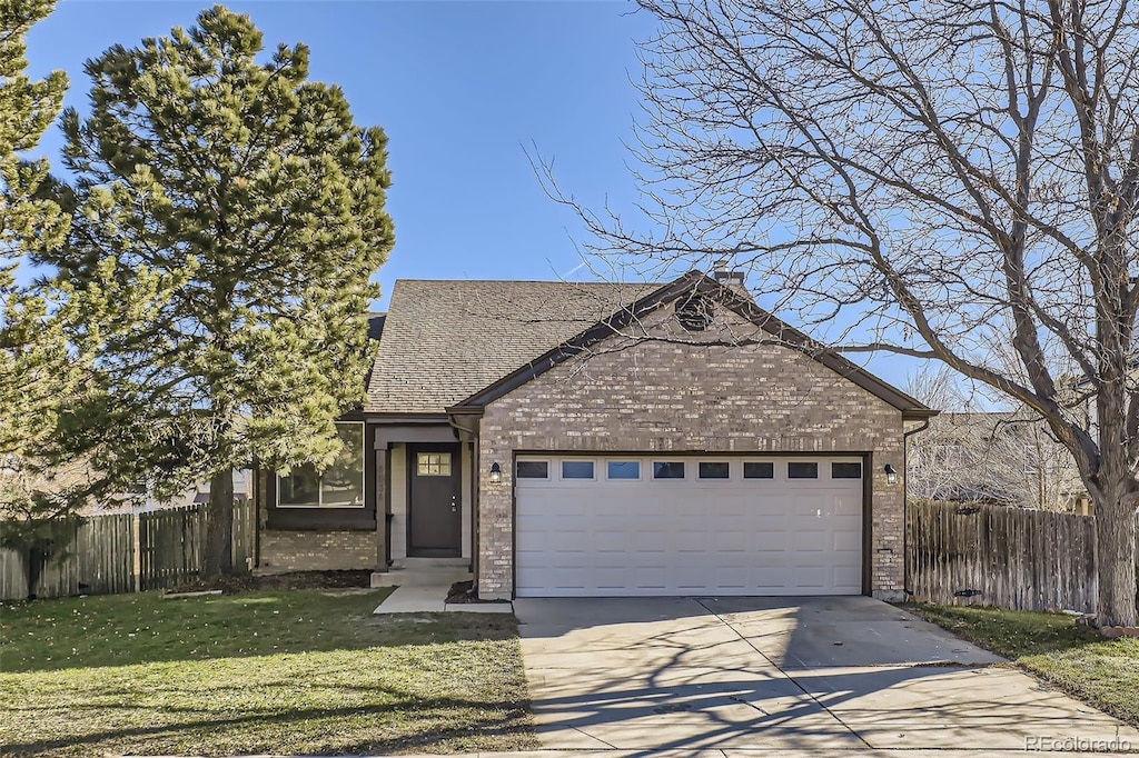 view of front of home with a front yard and a garage