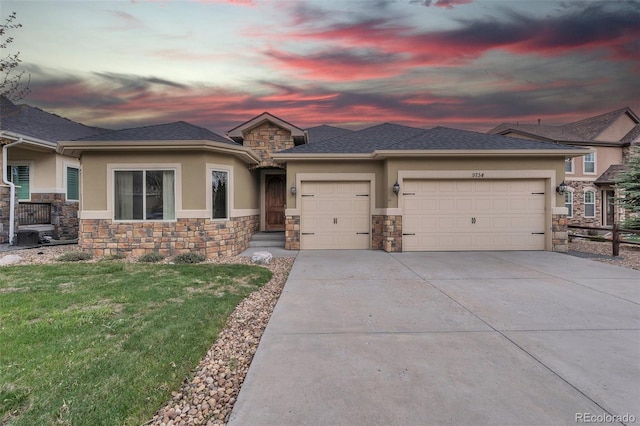 9754 W Ontario Pl, Littleton, CO 80128 - prairie-style house with stucco siding, stone siding, a garage, driveway, and a front yard