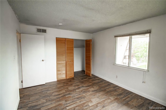 10211 Ura Ln Unit 9-308, Thornton, CO 80260 - unfurnished bedroom featuring dark wood-style flooring, a textured ceiling, and a closet