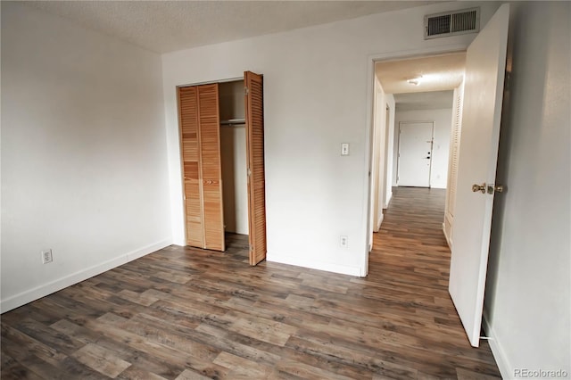 10211 Ura Ln Unit 9-308, Thornton, CO 80260 - unfurnished bedroom with dark wood finished floors, a closet, and a textured ceiling