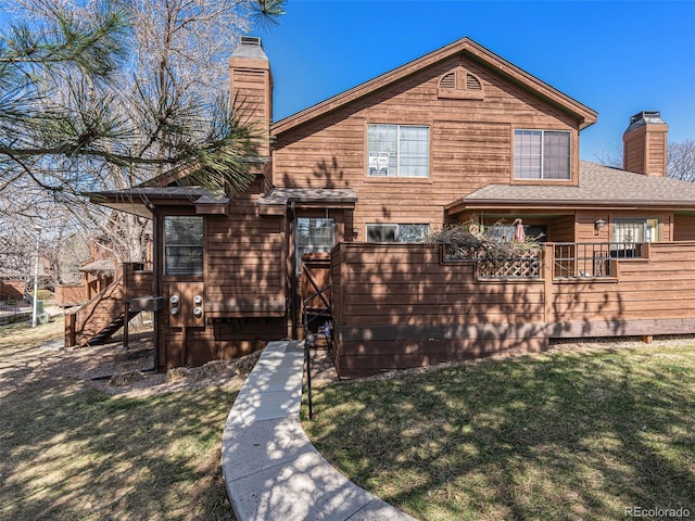 9365 W 80th Pl Unit C, Arvada, CO 80005 - view of front of home featuring a chimney, a wooden deck, and a front lawn