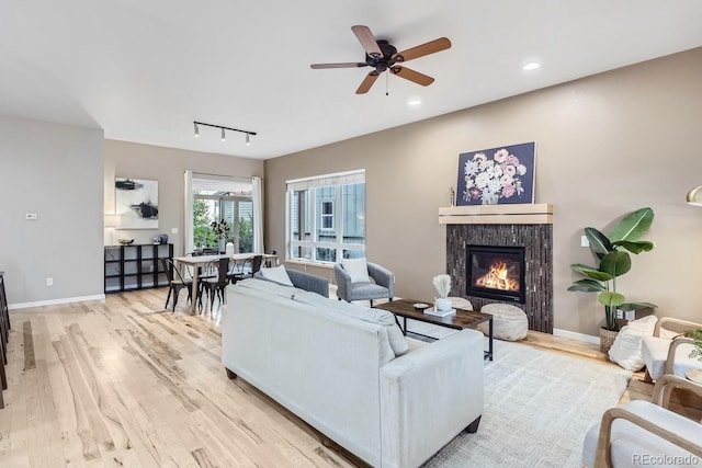 living room featuring light hardwood / wood-style flooring, ceiling fan, and track lighting