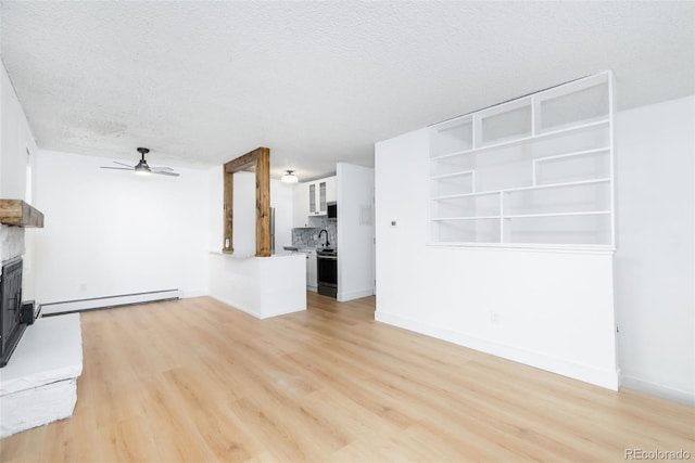 3035 Oneal Pkwy Unit 20V, Boulder, CO 80301 - unfurnished living room featuring baseboard heating, ceiling fan, a fireplace with raised hearth, light wood finished floors, and a textured ceiling