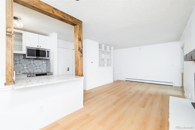 3035 Oneal Pkwy Unit 20V, Boulder, CO 80301 - unfurnished living room featuring a baseboard radiator, light wood-type flooring, and a textured ceiling