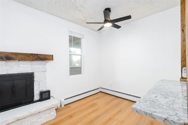 3035 Oneal Pkwy Unit 20V, Boulder, CO 80301 - unfurnished living room with a textured ceiling, wood finished floors, a ceiling fan, a baseboard radiator, and a fireplace