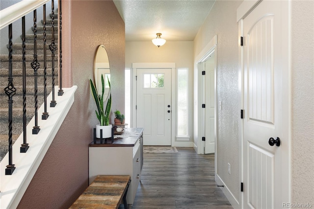 101 Wake St, Frederick, CO 80530 - foyer with a textured wall, stairs, and dark wood-style flooring