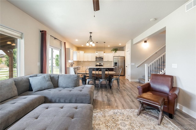 101 Wake St, Frederick, CO 80530 - living room featuring light wood-style floors, stairs, recessed lighting, and a chandelier