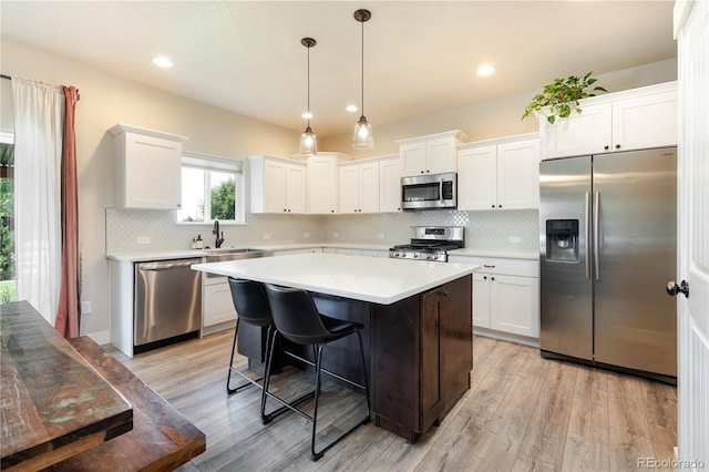 101 Wake St, Frederick, CO 80530 - kitchen with stainless steel appliances, light wood-style flooring, a kitchen island, white cabinetry, and recessed lighting