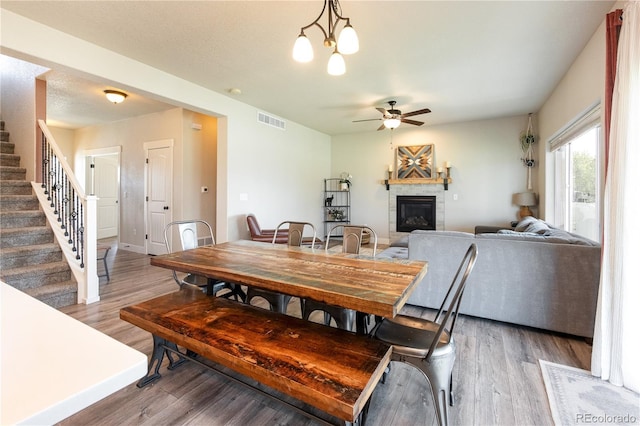 101 Wake St, Frederick, CO 80530 - dining area featuring ceiling fan, stairs, a fireplace, and light wood-style floors