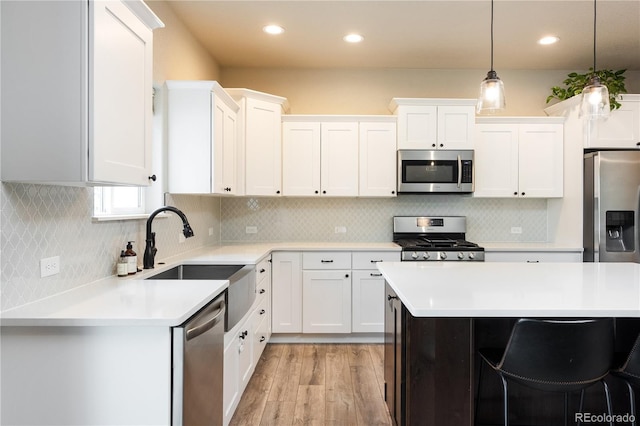 101 Wake St, Frederick, CO 80530 - kitchen with stainless steel appliances, light wood-type flooring, light countertops, white cabinetry, and pendant lighting