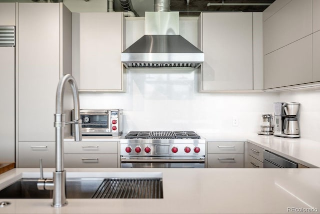 1610 Little Raven St Unit 302, Denver, CO 80202 - kitchen with stainless steel stove, wall chimney range hood, light countertops, and gray cabinetry
