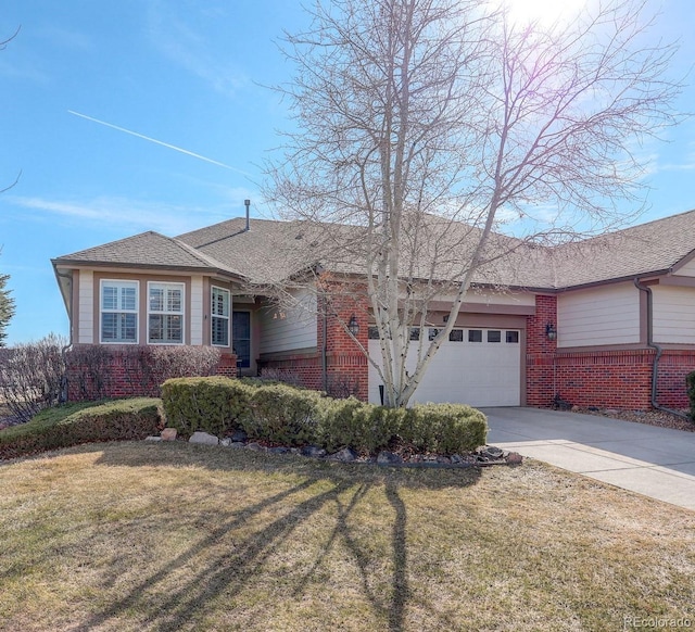 ranch-style house featuring a garage, driveway, brick siding, and a front yard