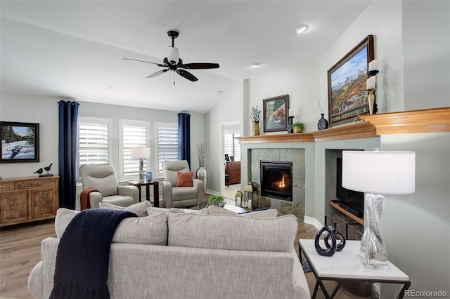 living area with a fireplace, light wood-style flooring, and a healthy amount of sunlight