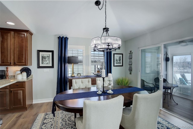 dining room featuring light wood-type flooring, an inviting chandelier, baseboards, and recessed lighting