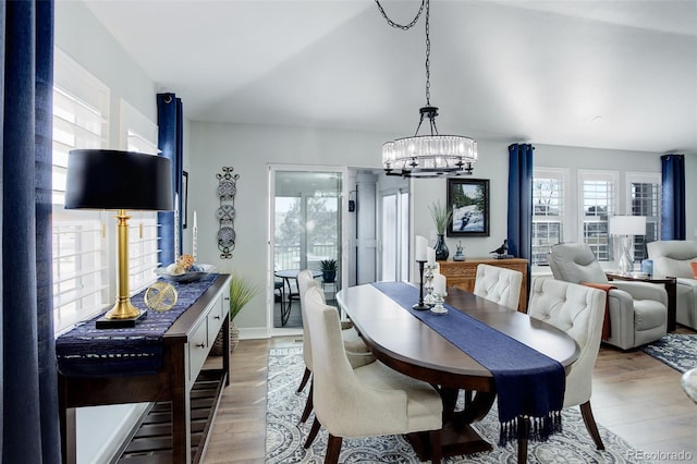 dining room featuring a healthy amount of sunlight, light wood-style floors, and an inviting chandelier