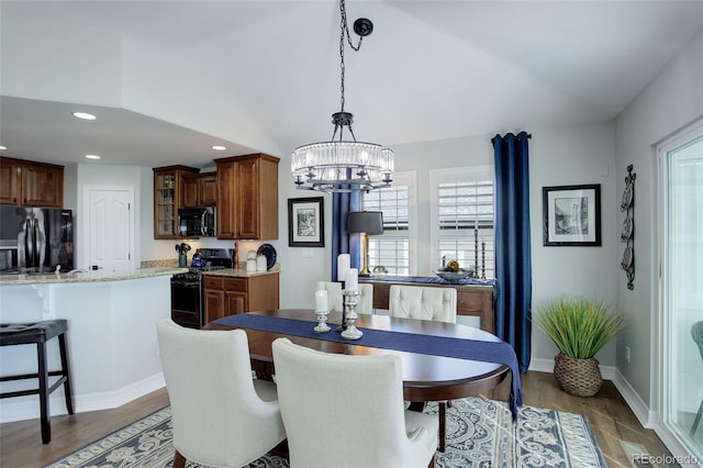 dining room featuring recessed lighting, a notable chandelier, baseboards, and wood finished floors