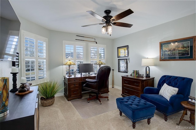 office featuring baseboards, a ceiling fan, and light colored carpet