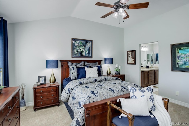 bedroom with lofted ceiling, light colored carpet, connected bathroom, and baseboards