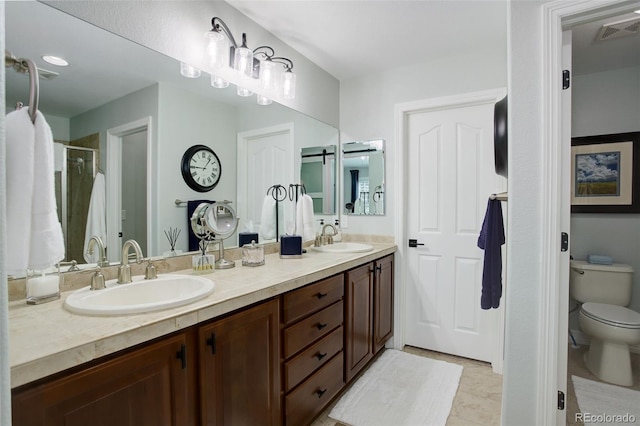 full bath with toilet, double vanity, visible vents, and a sink