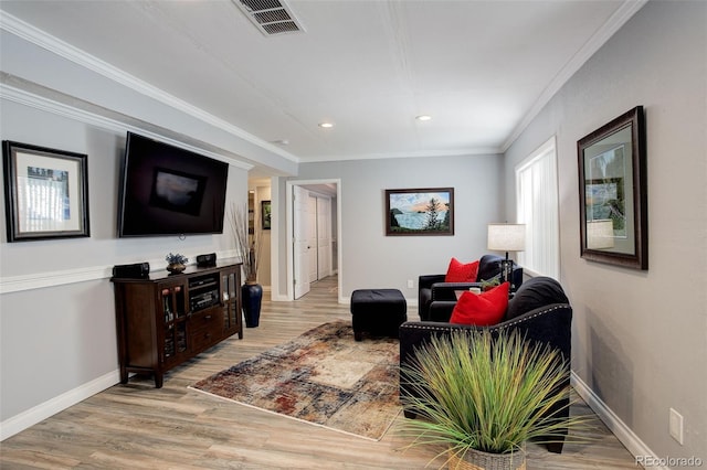 living area featuring light wood-style flooring, recessed lighting, visible vents, baseboards, and crown molding