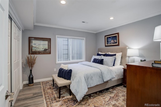 bedroom with crown molding, light wood-style flooring, and baseboards