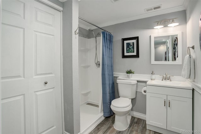 bathroom featuring a stall shower, visible vents, toilet, wood finished floors, and crown molding