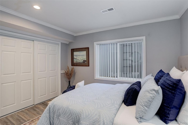 bedroom with visible vents, wood finished floors, crown molding, a closet, and recessed lighting