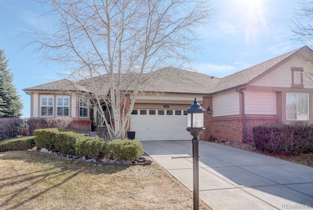 ranch-style home with brick siding, roof with shingles, concrete driveway, an attached garage, and a front lawn