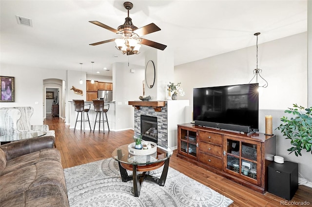 681 W Burgundy St Unit A, Highlands Ranch, CO 80129 - living area with a ceiling fan, wood finished floors, a fireplace, arched walkways, and baseboards