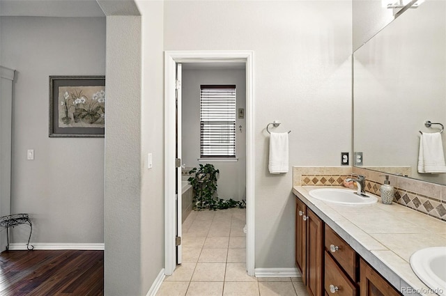 681 W Burgundy St Unit A, Highlands Ranch, CO 80129 - bathroom with double vanity, backsplash, baseboards, and tile patterned flooring