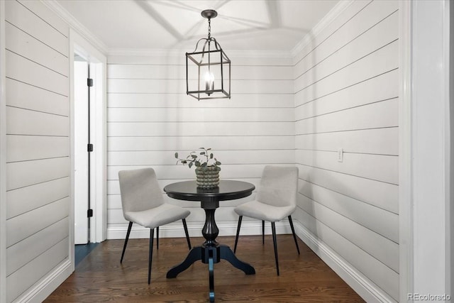 dining area with dark hardwood / wood-style flooring, ornamental molding, and a chandelier