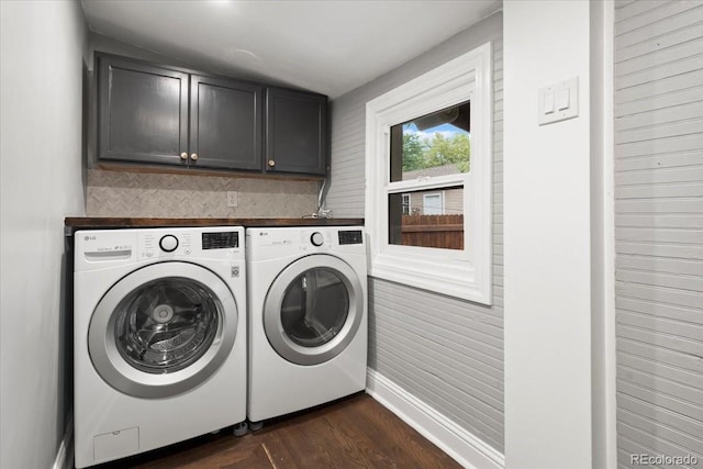 clothes washing area with cabinets, dark hardwood / wood-style floors, and washing machine and clothes dryer