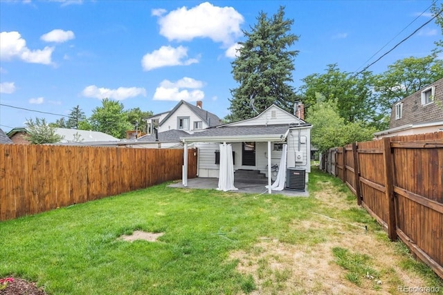 rear view of house featuring a lawn, central air condition unit, and a patio area