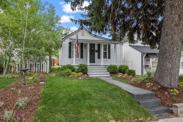 bungalow featuring covered porch and a front yard