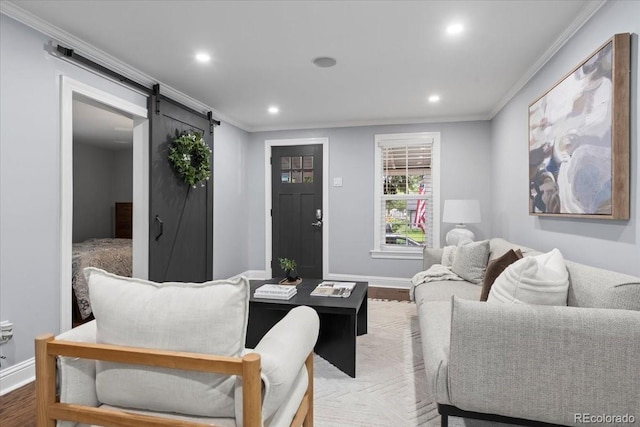 living room with hardwood / wood-style flooring, ornamental molding, and a barn door