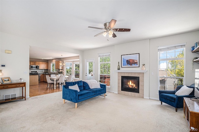 3543 S Ceylon Way, Aurora, CO 80013 - living room featuring light carpet, a tile fireplace, ceiling fan, and baseboards