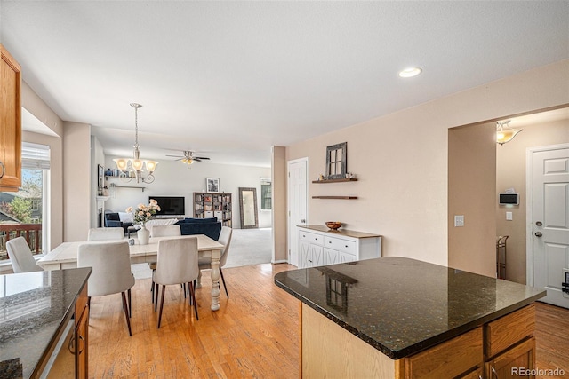 3543 S Ceylon Way, Aurora, CO 80013 - kitchen with a chandelier, light wood-style flooring, open floor plan, pendant lighting, and dark stone countertops