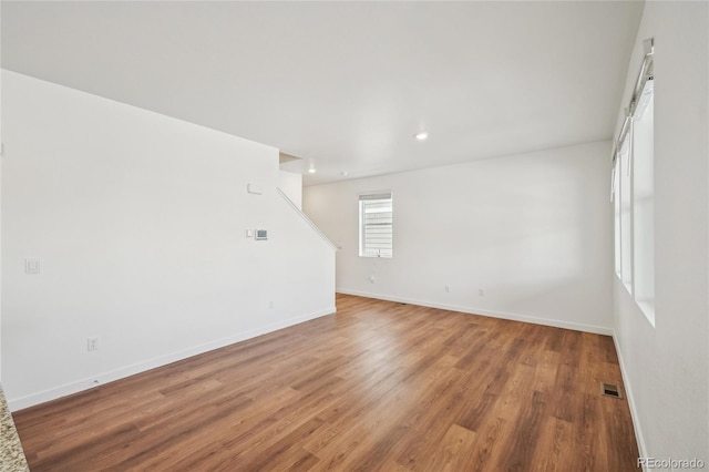 unfurnished room with hardwood / wood-style floors