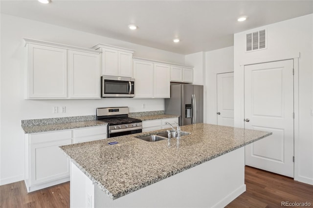 kitchen with stainless steel appliances, sink, a kitchen island with sink, and white cabinets