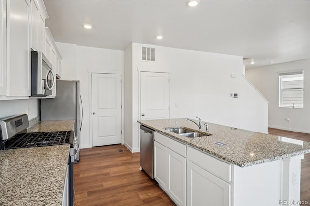 kitchen featuring sink, an island with sink, white cabinets, and appliances with stainless steel finishes