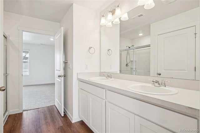 bathroom with vanity, an enclosed shower, and hardwood / wood-style floors