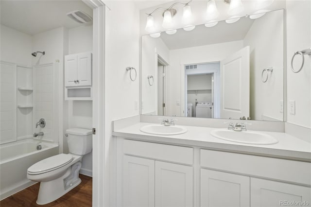 full bathroom with hardwood / wood-style floors, vanity,  shower combination, toilet, and washer and clothes dryer