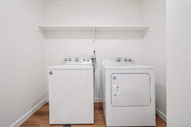 clothes washing area featuring hardwood / wood-style floors and washer and dryer