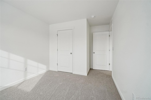 unfurnished bedroom with light carpet and a closet