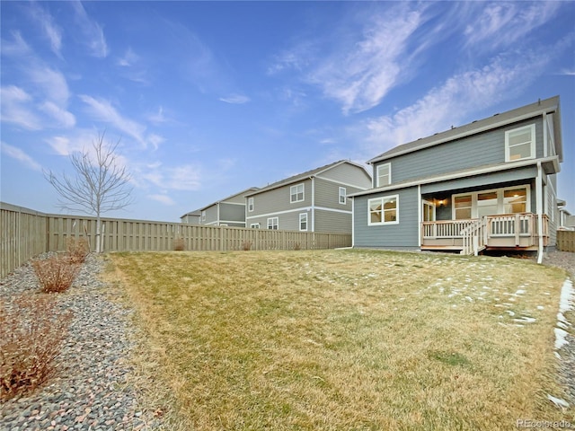 back of property with a wooden deck and a yard