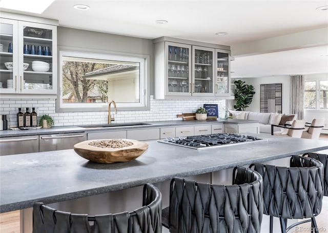 kitchen featuring a sink, decorative backsplash, a breakfast bar, and stainless steel appliances