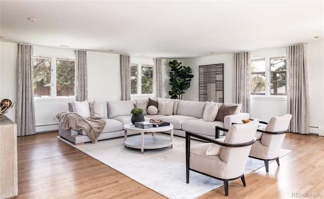 living room with a baseboard radiator and light wood-style flooring