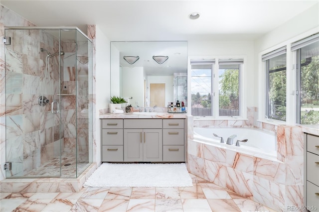 full bath featuring vanity, a stall shower, a garden tub, and marble finish floor