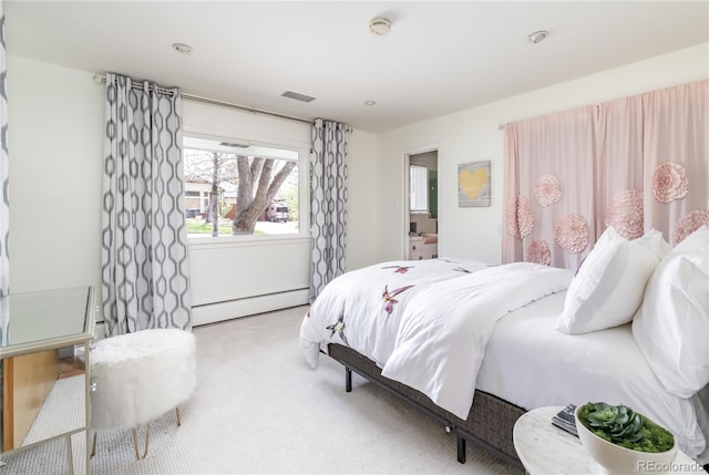 bedroom featuring a baseboard heating unit, carpet flooring, and visible vents