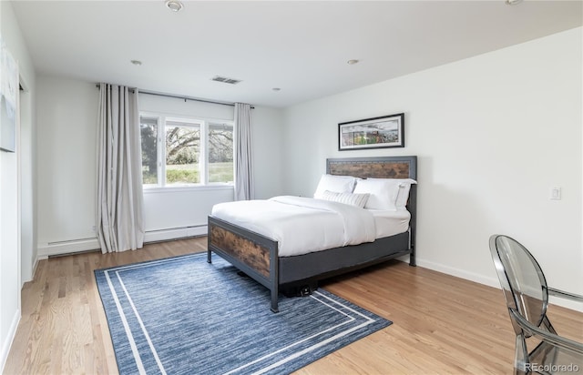 bedroom featuring visible vents, baseboards, a baseboard radiator, recessed lighting, and light wood-style flooring